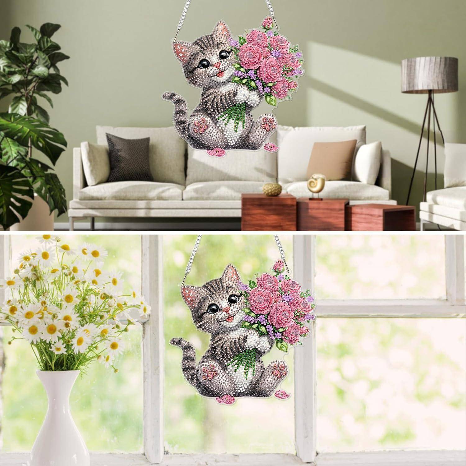 Funkelnde katzenförmige Blumenwandhanging-Dekoration mit rosa Blüten, die in einem Wohnzimmer und neben einem Fenster ausgestellt sind.