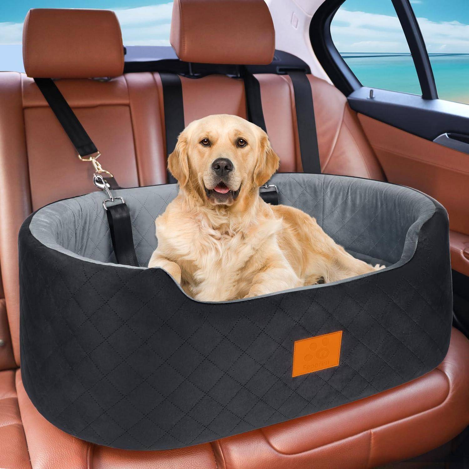Goldenretriever sitzt in einer schwarzen gesteppten Hundeautositz-Hängematte auf der Rückbank eines Autos, gesichert durch eine Leinenanbringung.