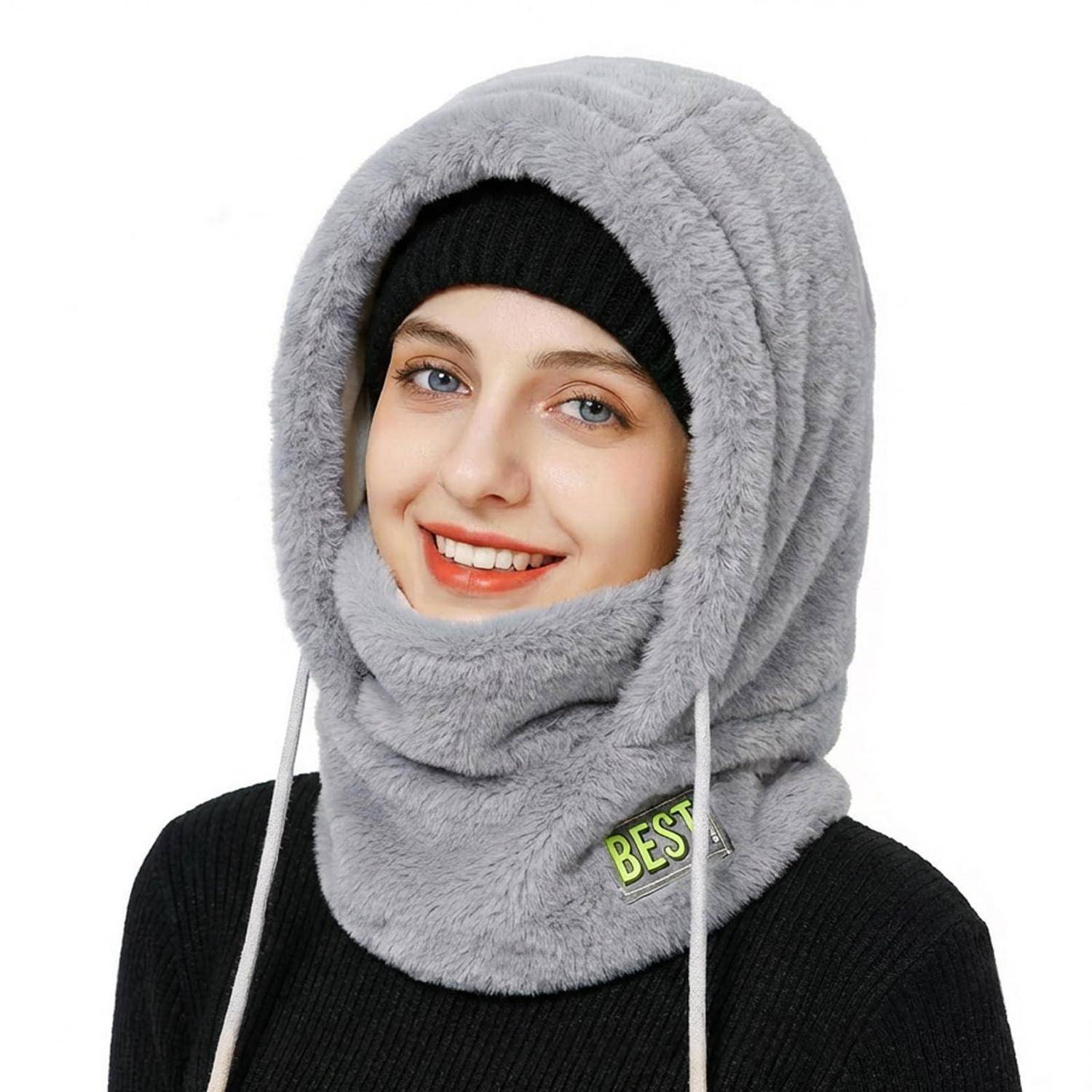 Lächelnde Frau, die einen grauen, künstlichen Fellkapuzen-Winterbalaklava und eine schwarze Strickmütze trägt, mit Zugbändern und einem „BEST