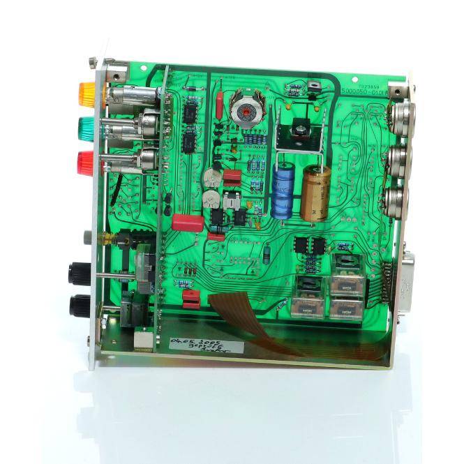 Nahaufnahme eines grünen elektronischen Leiterplattenmoduls mit mehreren Anschlüssen, Kondensatoren, Chips und Verdrahtung in einem Metallgehäuse montiert.