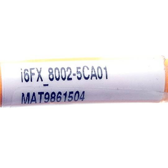 Großaufnahme eines weißen zylindrischen Rohrs mit der Beschriftung „i6FX 8002-5CA01" und „MAT9861504"".