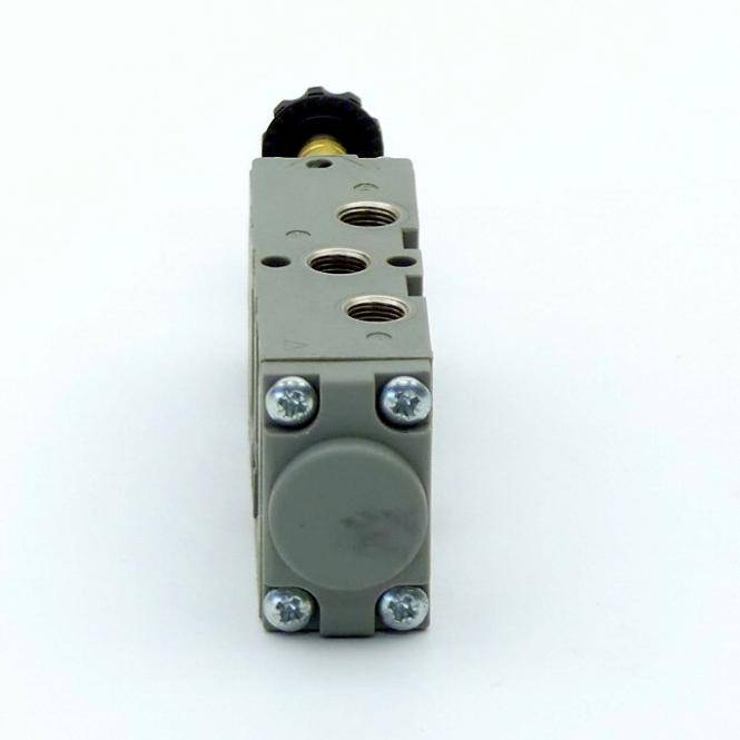 Graues industrielles pneumatisches Ventil oder Solenoidblock, frontal dargestellt, mit mehreren Gewindeanschlüssen und vier sichtbaren Schrauben auf weißem Hintergrund.