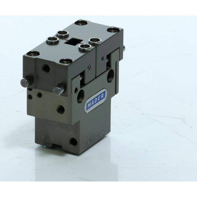 Schwarzer Industrialmetallblock mit mehreren Schraubenlöchern und einem „MADER