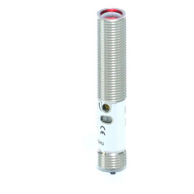 Zylindrischer Metallsensor oder -schalter mit Gewinde-Gehäuse, seitlichen Anzeigebeschädigungen und einer roten Oberlinsus auf weißem Hintergrund.