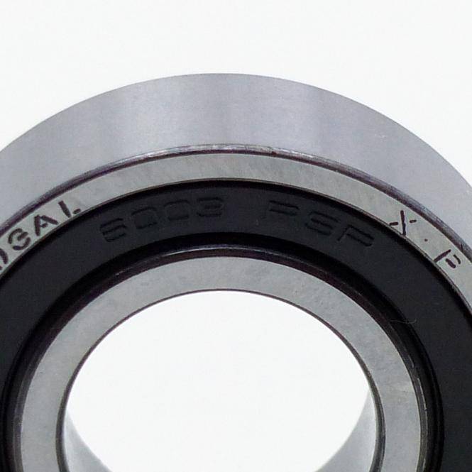 Nahaufnahme eines Metall- und Gummi-Kugellagers oder einer Dichtung, die die kreisförmige Öffnung und eingravierte Markierungen am äußeren Ring zeigt.