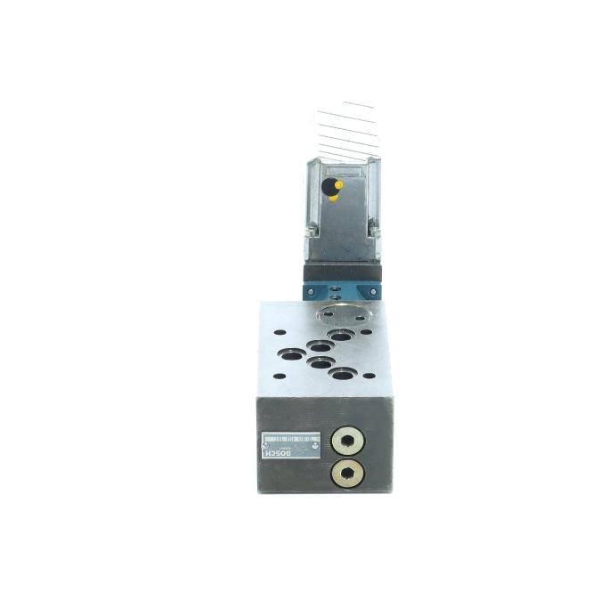 Industrieller Metallventilblock mit Anschlüssen und einer montierten Magnetspule auf weißem Hintergrund.