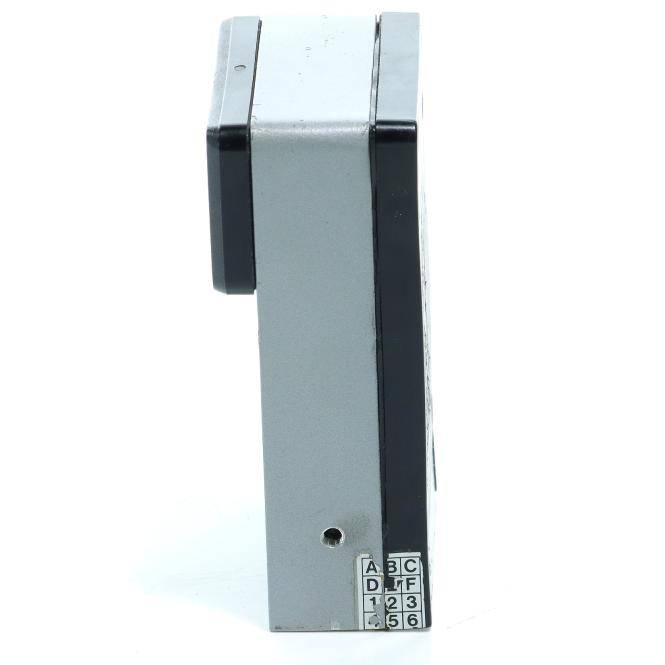 Ein kompaktes graues elektronisches Gerät, von der Seite gezeigt, mit schwarzen Endkappen und einem kleinen beschrifteten Tastenfeld am unteren Ende.