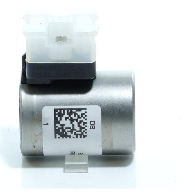Kleine zylindrische elektronische Komponente mit einem weißen QR-Code-Etikett und einem durchscheinenden Kunststoffstecker oben, gezeigt vor einem einfachen weißen Hintergrund.
