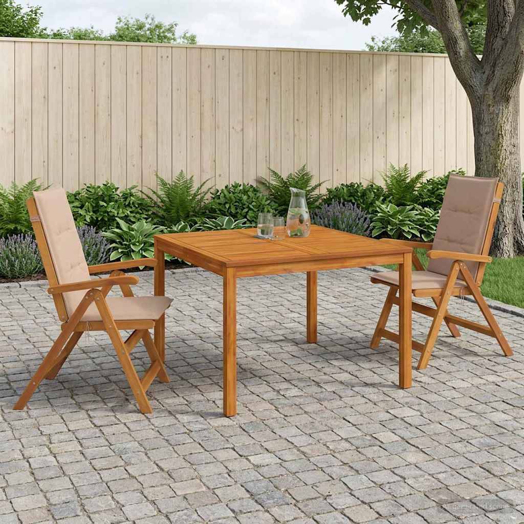 Esszimmergarnitur für die Terrasse mit quadratischem Holztisch, zwei beigen gepolsterten Klappstühlen auf Steinplatten neben einem Zaun und einem Garten.