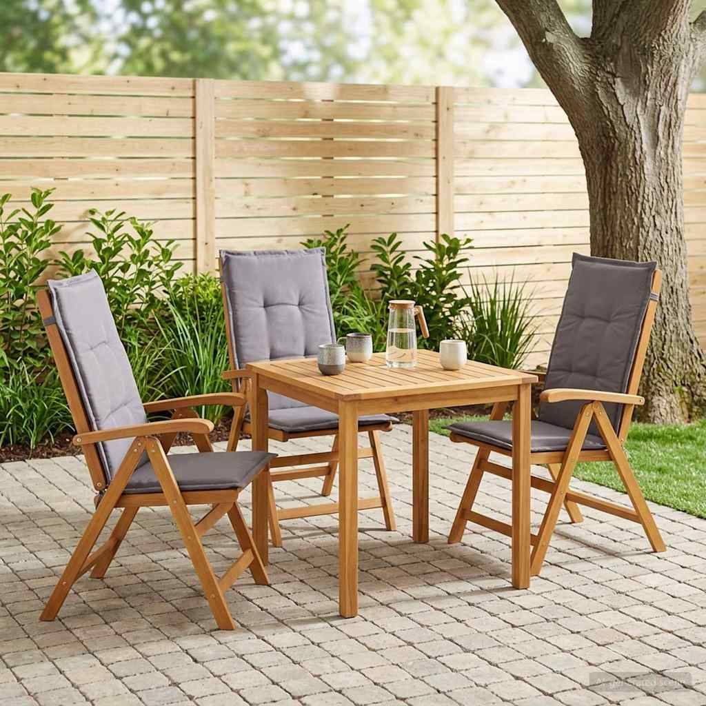 Outdoor-Essbereich mit drei gepolsterten Holzstühlen um einen quadratischen Tisch, aufgestellt auf einer Steinterrasse neben einem Zaun und einem Baum.