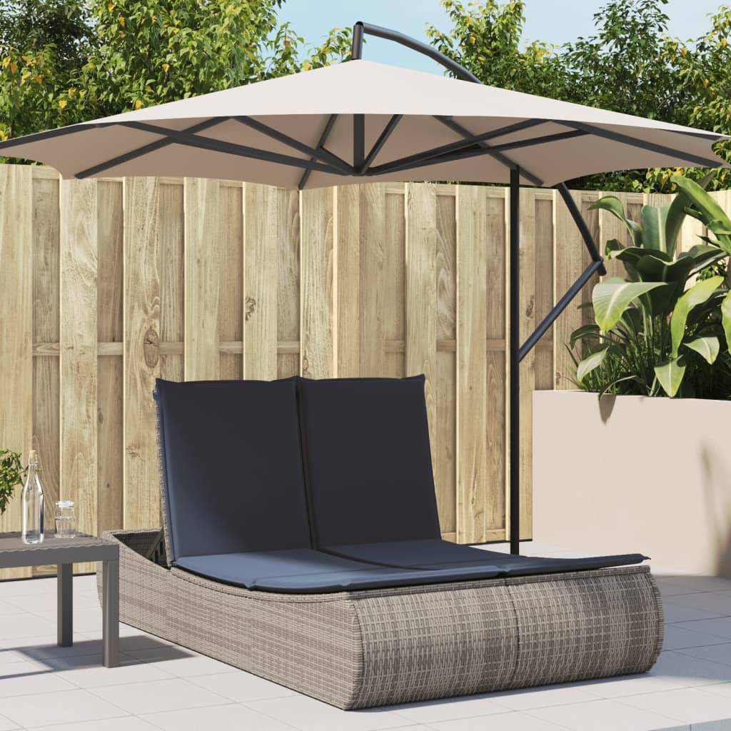 Outdoor-Terrassenszene mit einer Korbgeflecht-Doppelliege und großem beigefarbenem Sonnenschirm neben einem Holzzaun und Topfpflanzen.