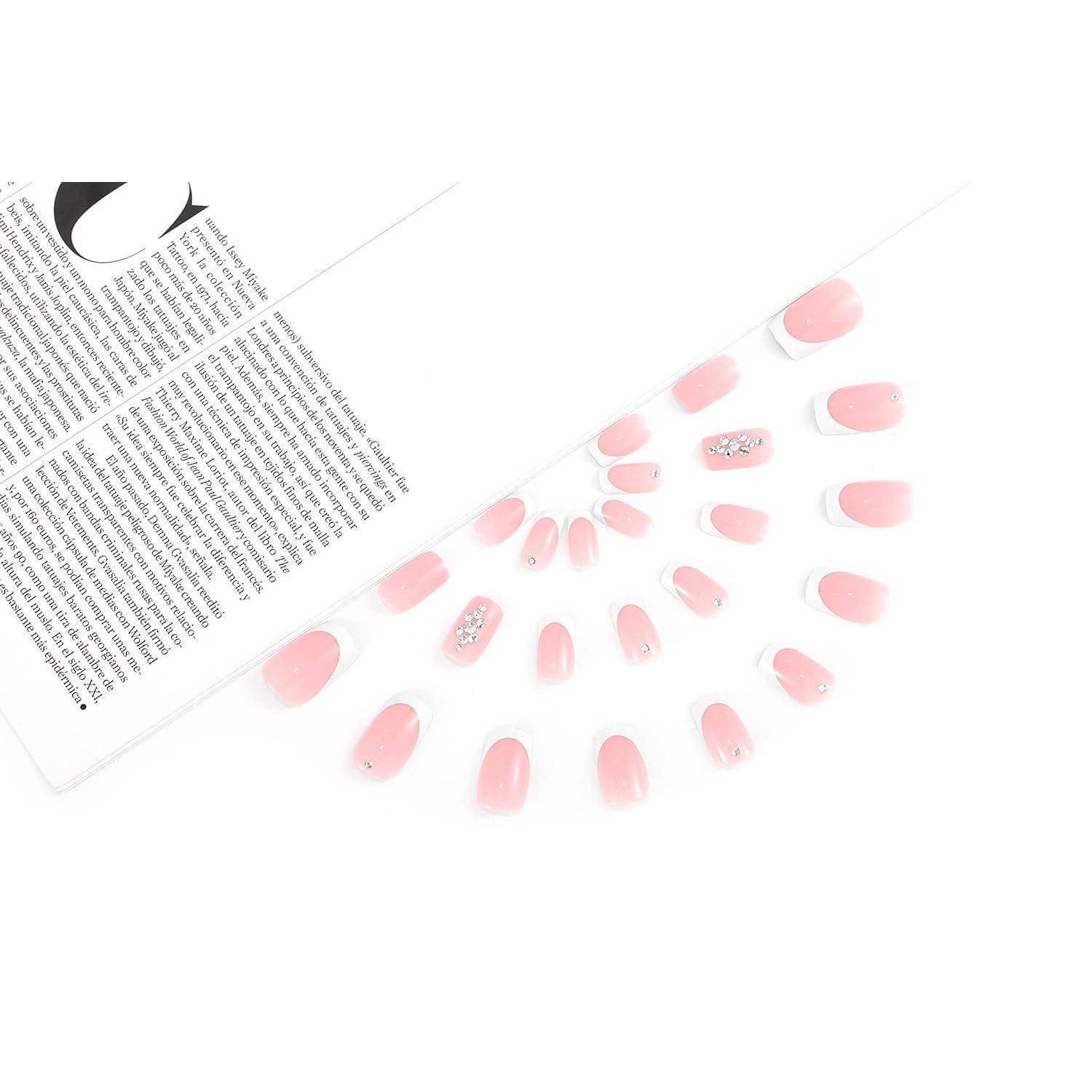 Draufsicht auf rosa künstliche Nägel, die fächerförmig neben einer Magazinseite auf weißem Hintergrund angeordnet sind.