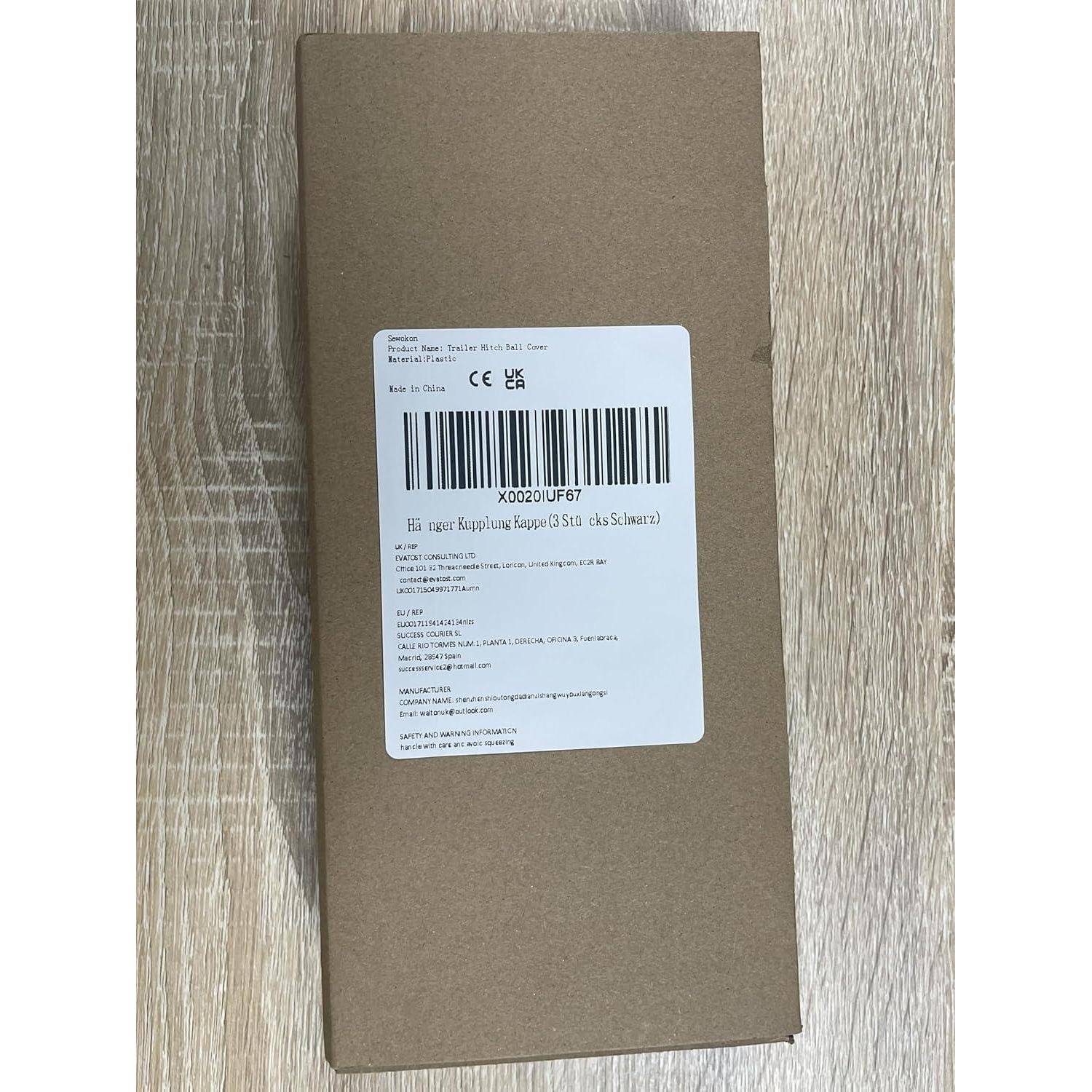 Ein braunes Kartonproduktkarton mit einem weißen Barcode-Etikett und Produktinformationen, fotografiert auf einem Holzboden.
