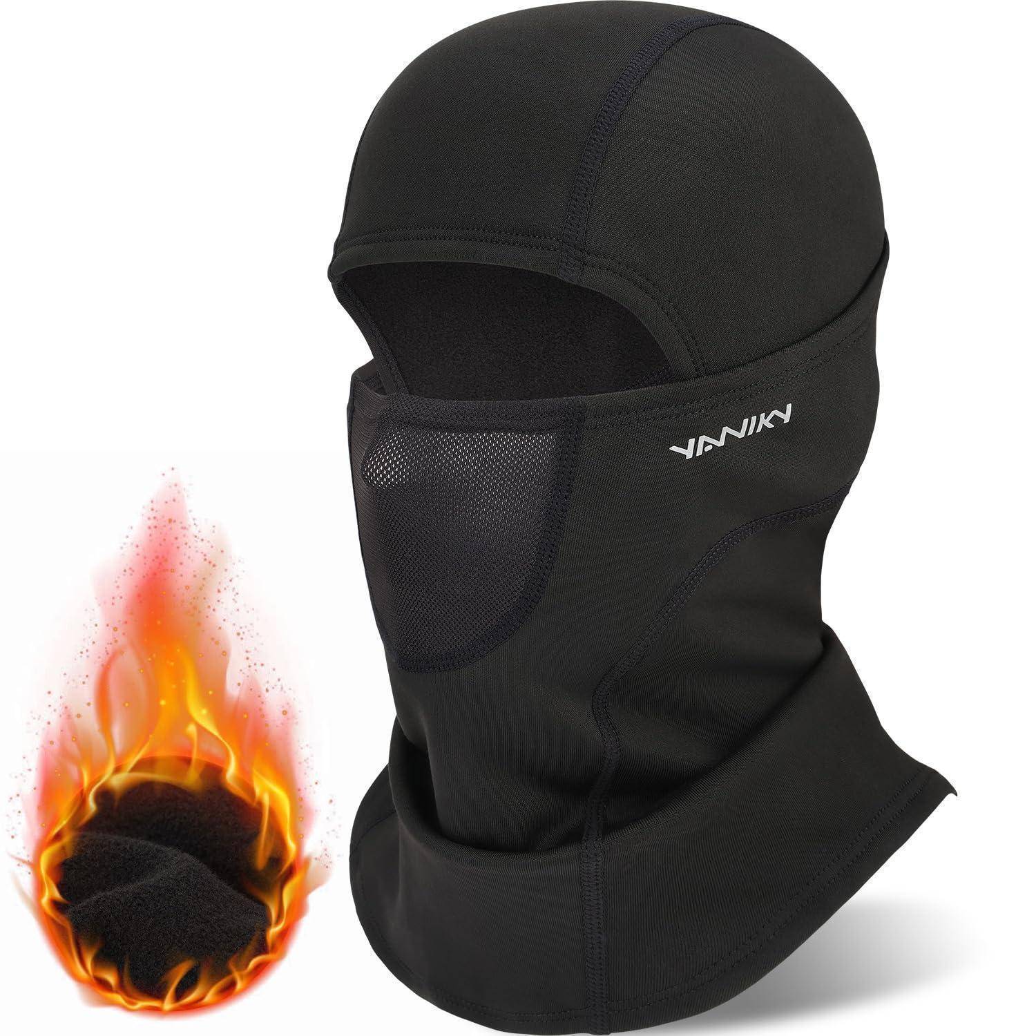 Schwarze Sturmhaube mit vollständiger Gesichtsbedeckung und Mesh-Mundöffnung, daneben ein Flammen-Symbol, das feuerfeste Schutzwirkung anzeigt.