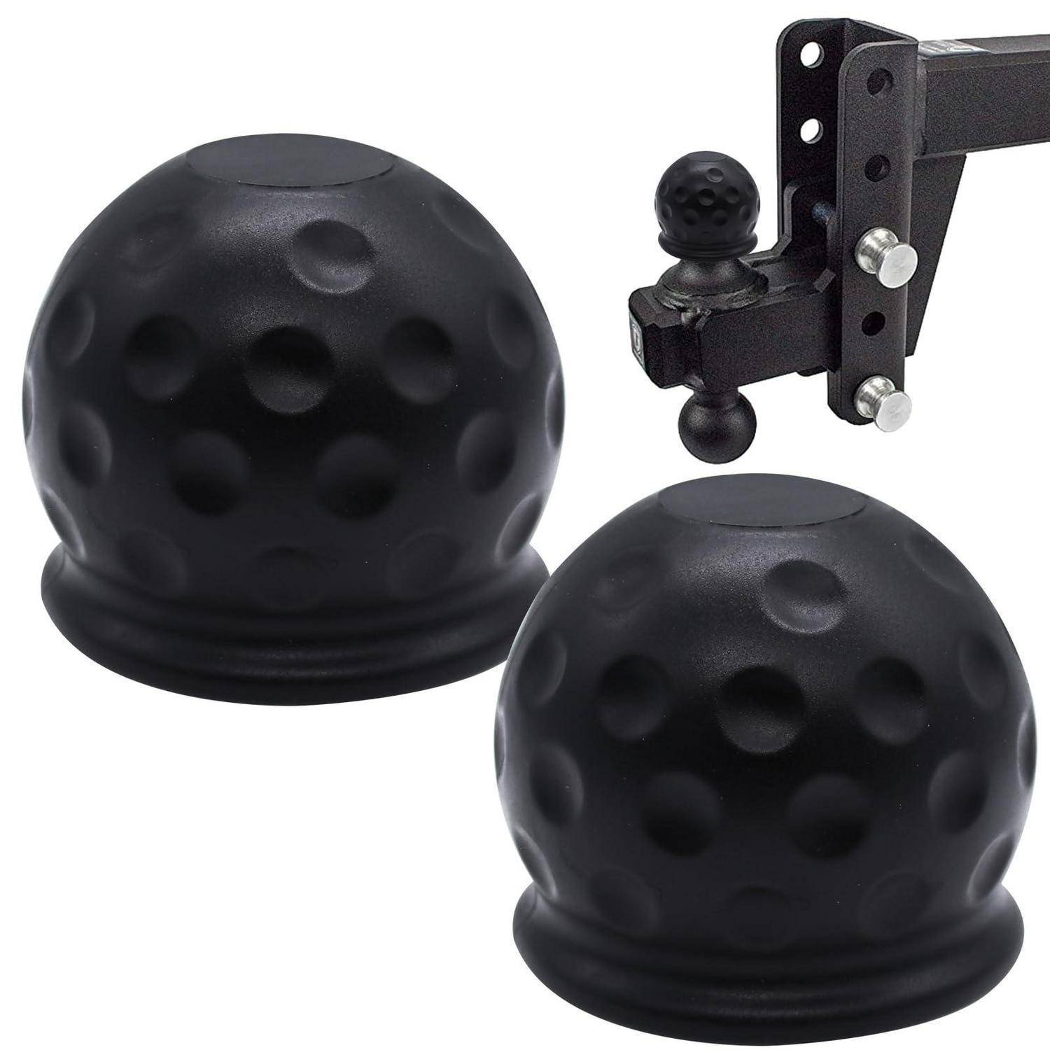 Zwei schwarze, mit Dellen versehene Golfball-ähnliche Anhängerkupplungsabdeckungen und eine auf einem schwarzen Metallgestell montierte Anhängerkupplung.