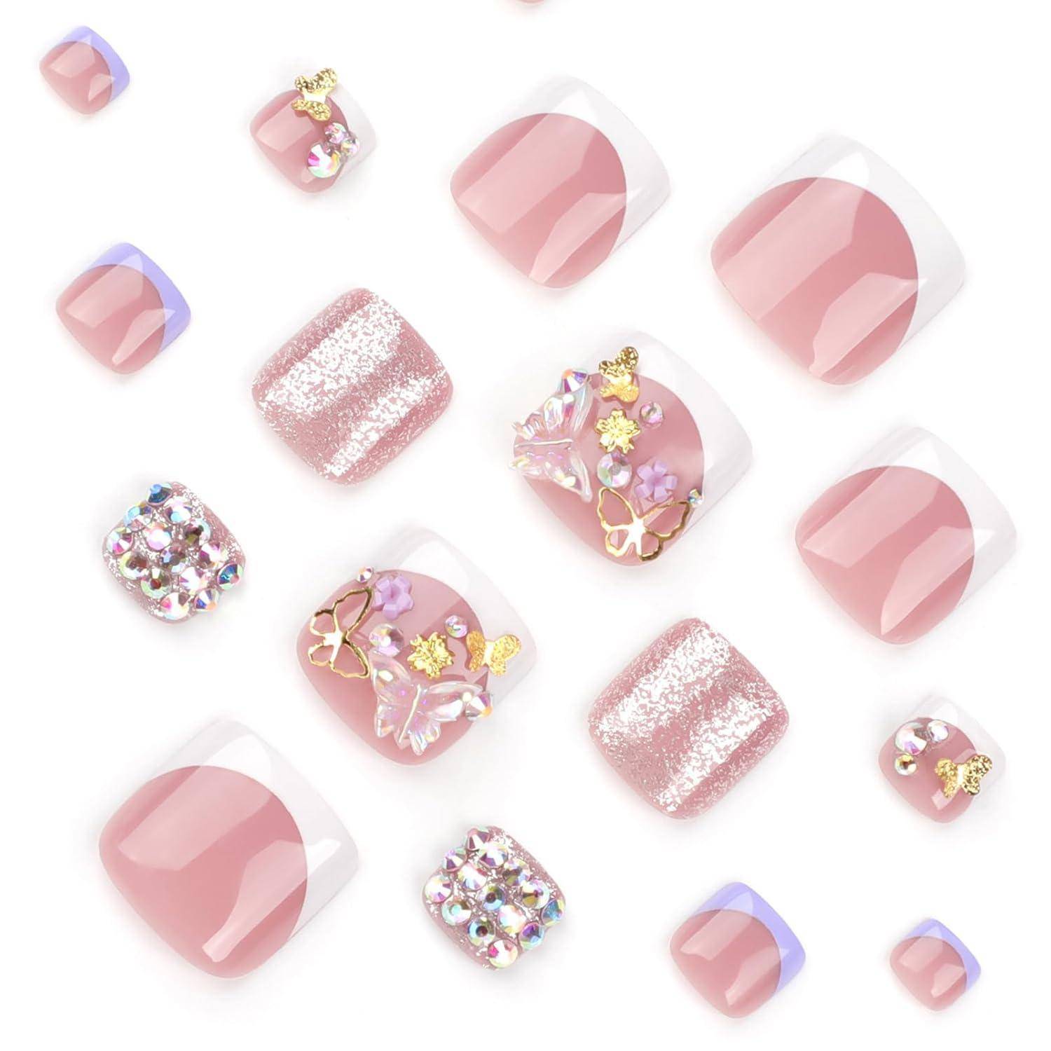 Sortierte rosafarbene künstliche Nägel auf weißem Hintergrund, einschließlich Glitter-, Strass- und Schmetterlings-Design.