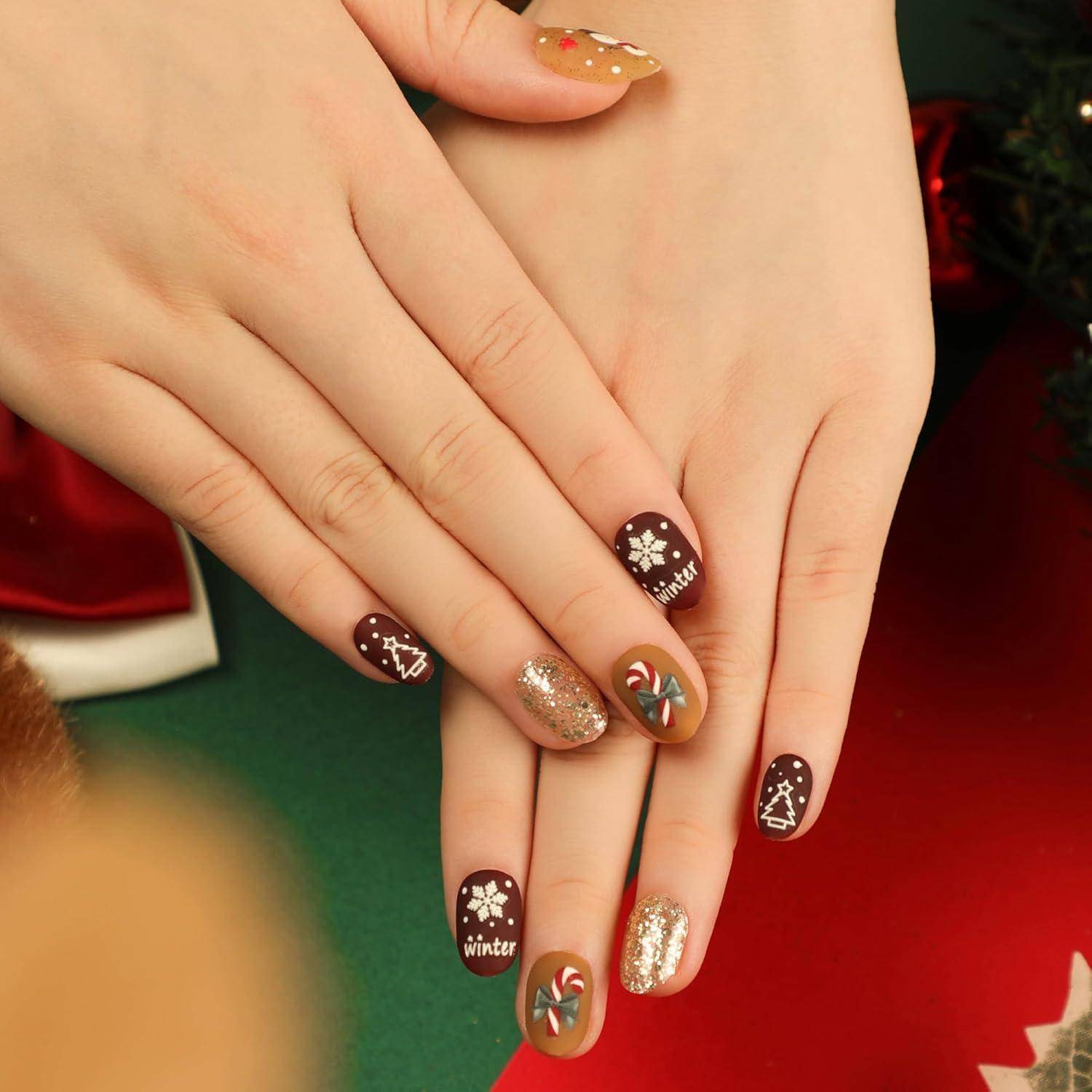 Nahaufnahme von Händen mit festlicher Winternagelkunst, einschließlich Zuckerstangen, Schneeflocken, Bäumen und dem Wort 