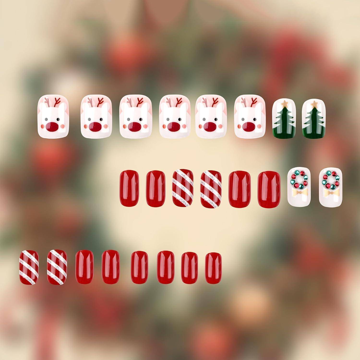 Weihnachtliches Nagelkunst-Display mit Reihen von Kunstnägeln zum Aufdrücken: weiße Rentier- und Weihnachtsbaumdesigns, rote durchgehend gefärbte Nägel, rot-weiß gestreifte Nägel und festliche Verzierungsnägel.
