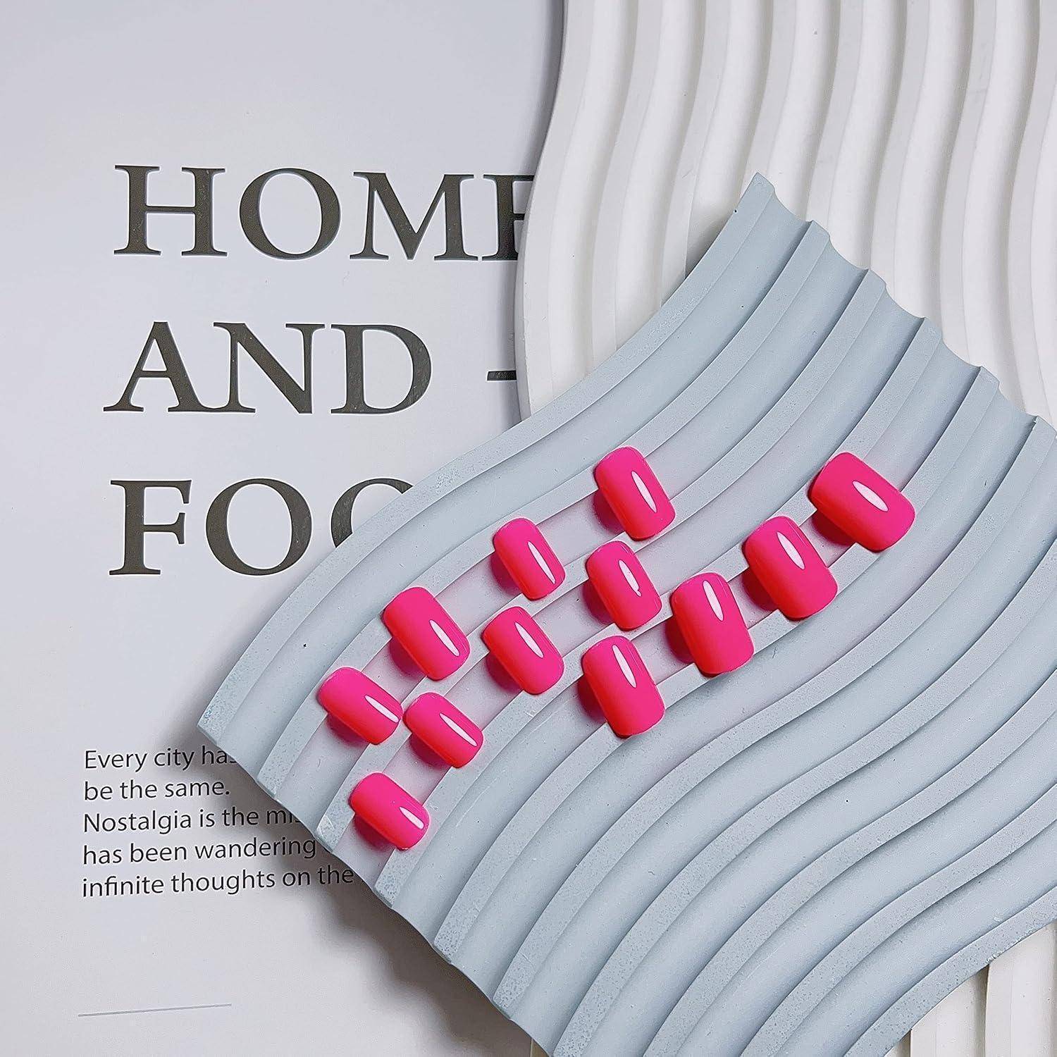 Abstrakte Grafik von leuchtend rosa kapselförmigen Elementen, die auf geschichteten hellblauen welligenügen über einer Magazinseite mit Teiltext „HOME