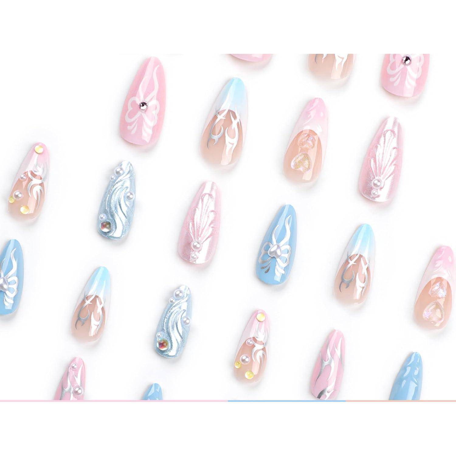 Pastellblau, rosa und pfirsichfarbene künstliche Nägel mit zarten Wirbeln und Rhinstein-Akzenten auf weißem Hintergrund angeordnet.