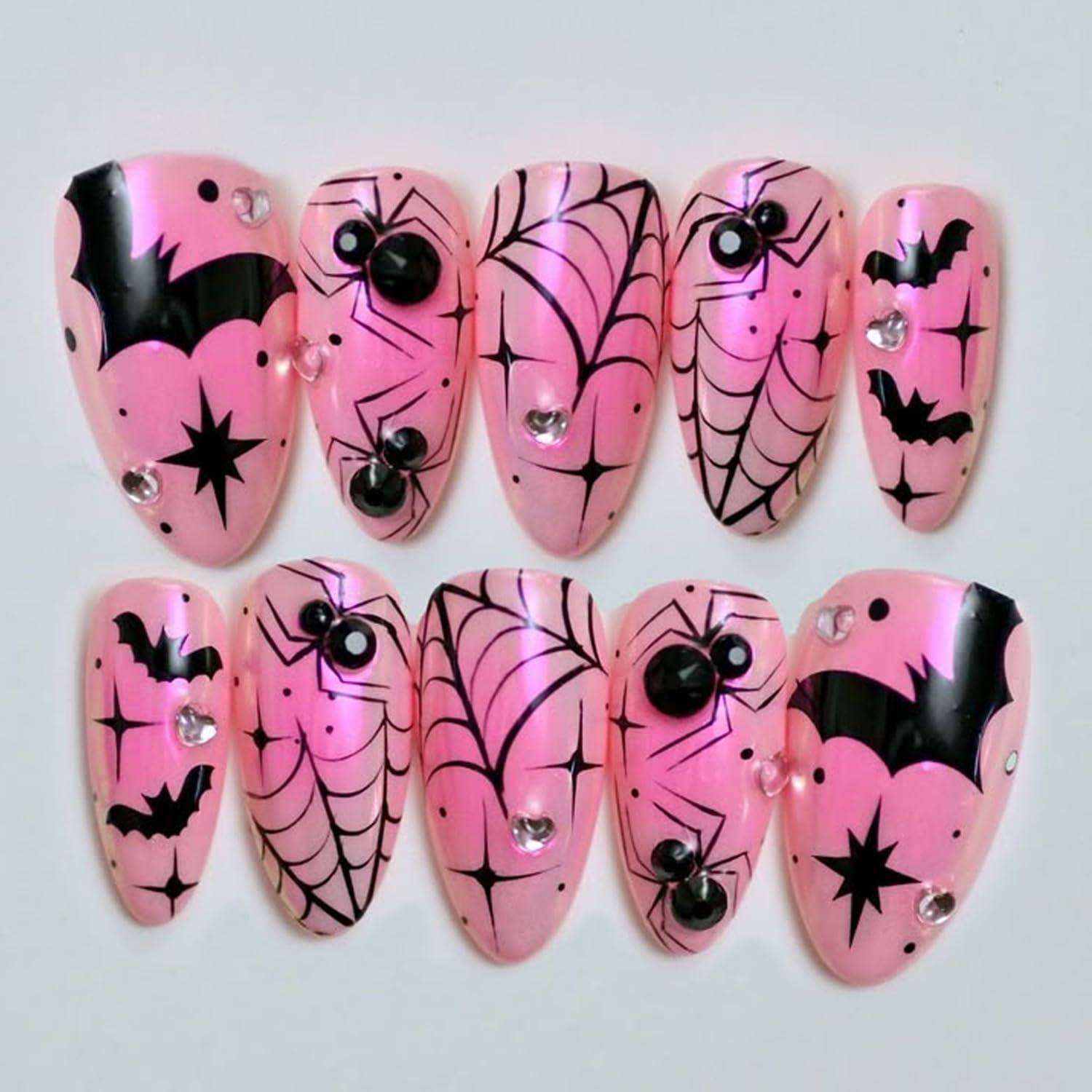 Rosa Halloween-Kunstnägel mit schwarzen Fledermäusen, Spinnen, Spinnweben, Sternen und Strass-Akzenten, angezeigt in zwei Reihen.