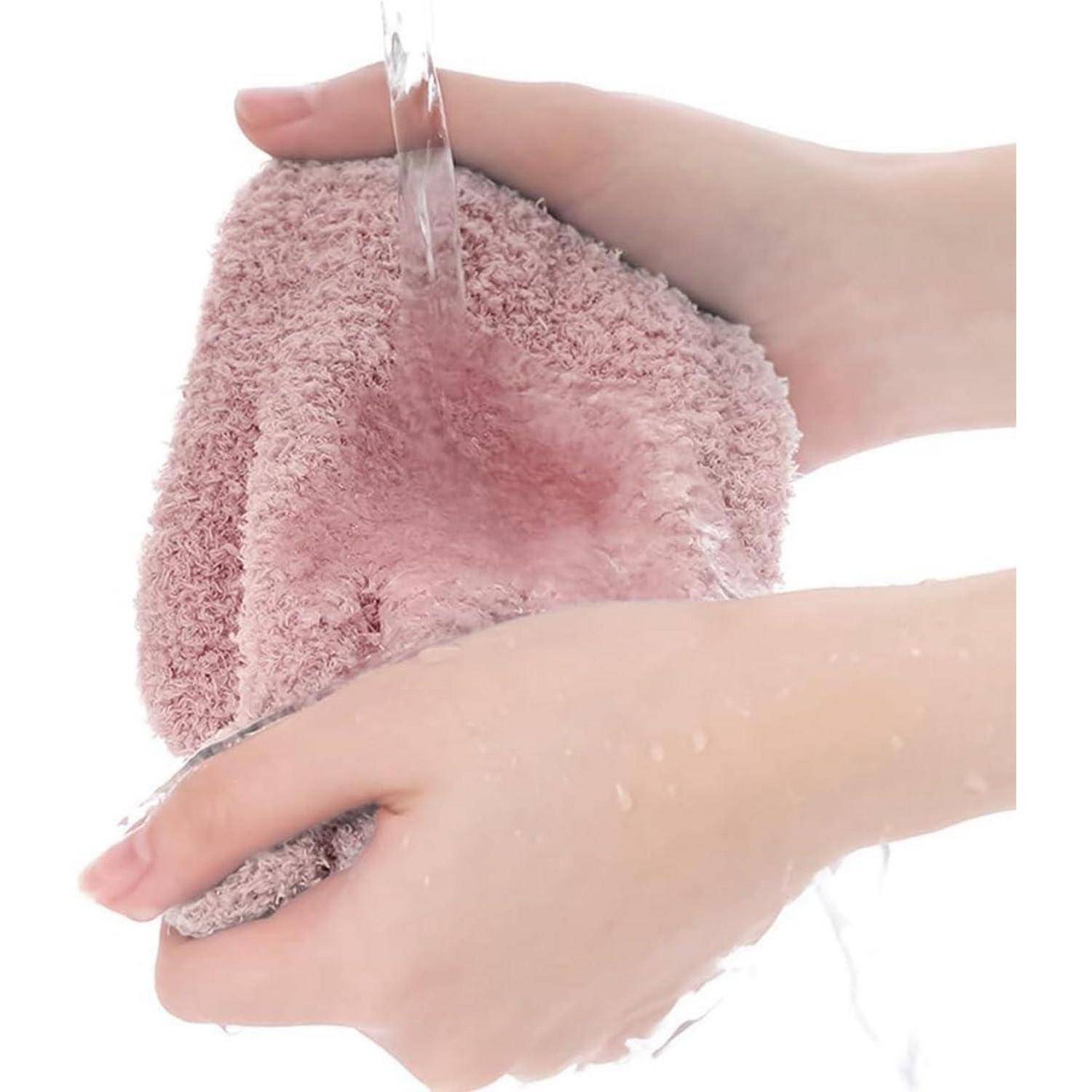 Hände, die unter fließendem Wasser einen rosa Badeschwamm ausspülen, um ihn zu reinigen.