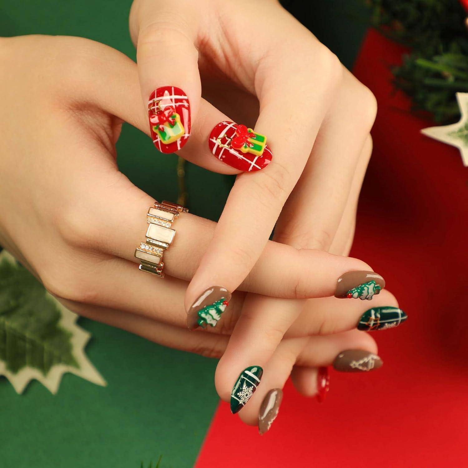 Nahaufnahme gepflegter Hände mit festlichem Weihnachts-Nageldesign in Rot, Grün und Gold mit Geschenk- und Schneeflocken-Motiven.