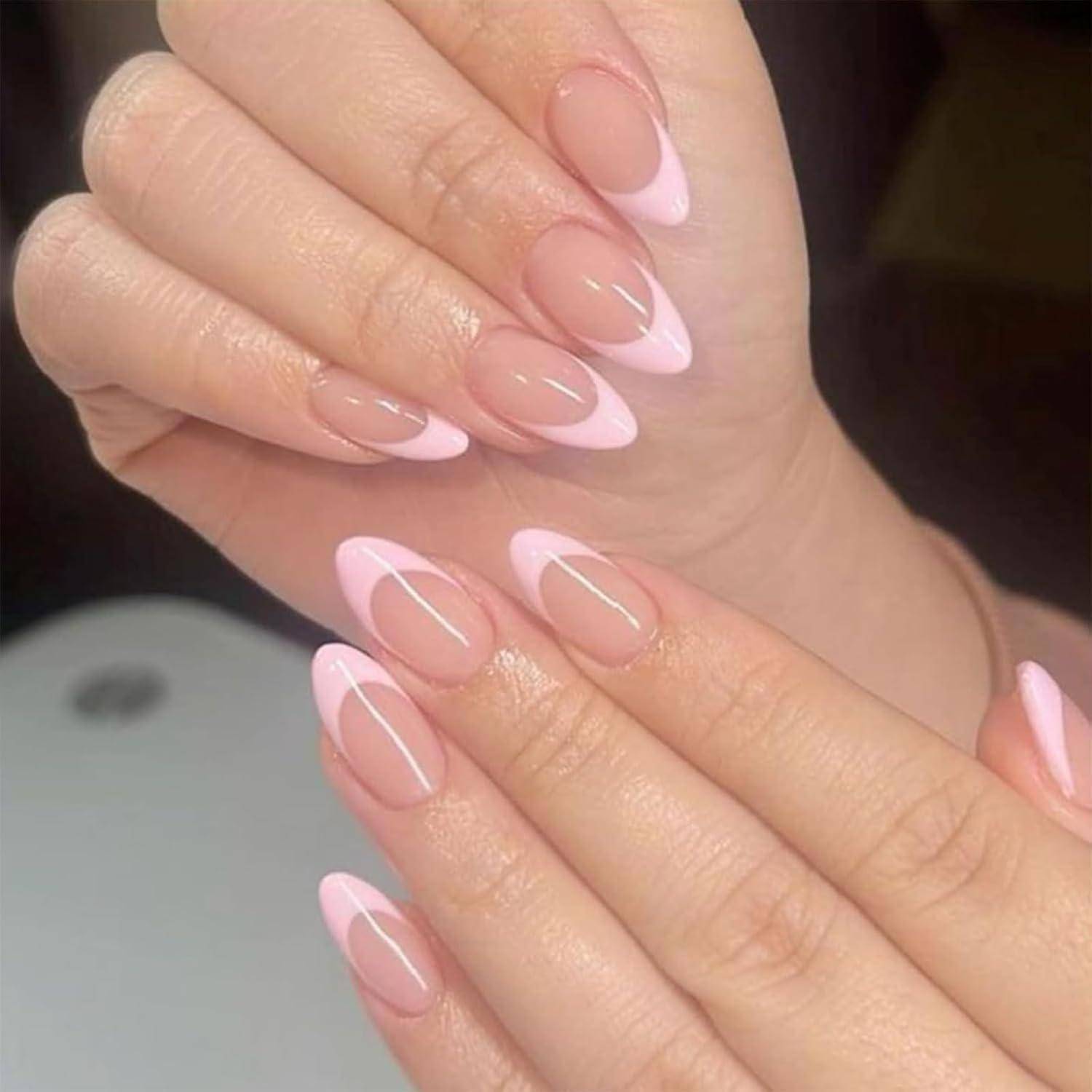 Nahaufnahme von Händen mit glänzender rosa French Manicure und langen mandelförmigen Nägeln.