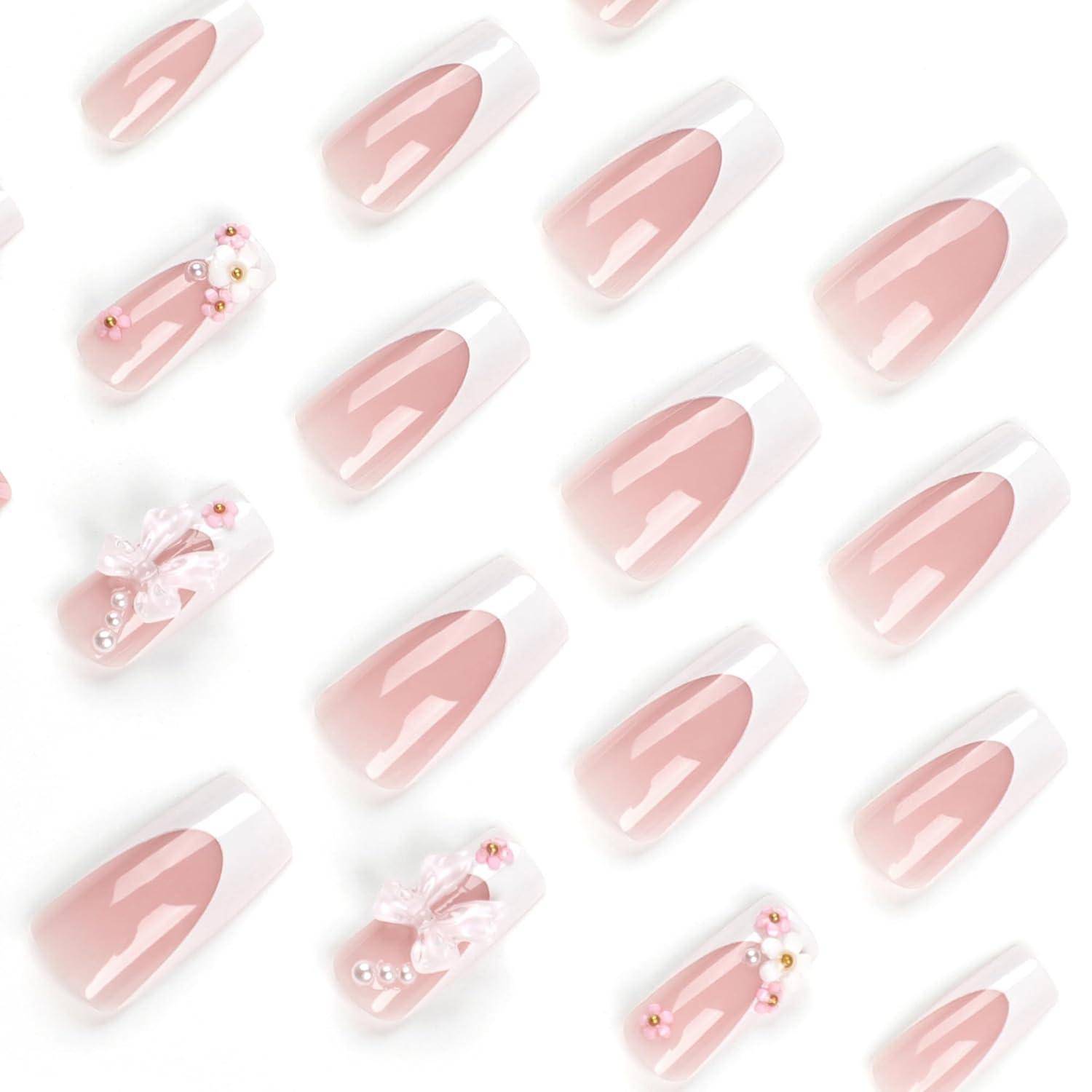 Rosa glänzende Kunstnägel in Mandelform zum Aufkleben, einschließlich einfarbiger nude-rosa Nägel und einige mit Perlen, Schleifen und floralen Akzenten verziert.