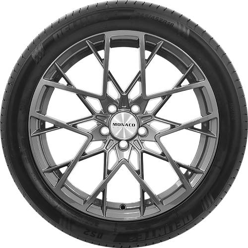 Grauer Autoreif und Leichtmetallrad mit aufwändigem mehrteiligem Speichenmuster; die Mittelkappe trägt die Aufschrift „MONACO