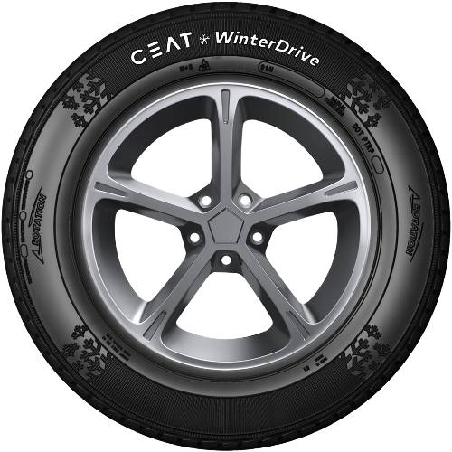Nahaufnahme eines Autoreifens mit silberner Leichtmetallfelge und CEAT WinterDrive Winterreifen, vor einem schwarzen Hintergrund dargestellt.