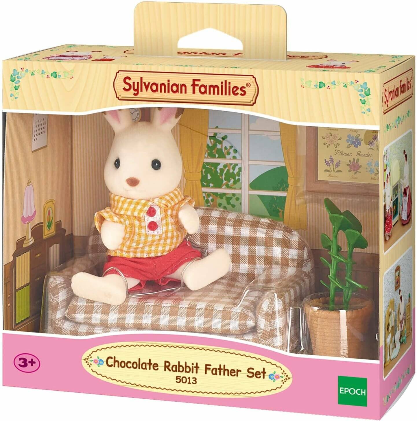 Sylvanian Families Schokoladen-Kaninchen-Vater-Set mit einer sitzenden Hasenfigur auf einem Sofa in einer Raumszene, ab 3 Jahren.