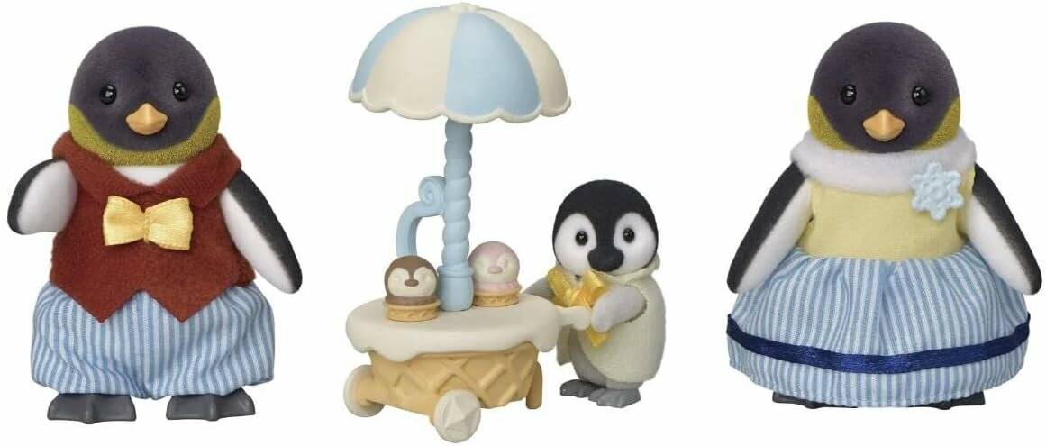 Drei dekorative Pinguinfiguren: eine in einer Weste und Fliege, eine bei einem Dessert-Tablett unter einem Regenschirm, und eine in einem blauen Kleid mit einer Schneeflocken-Brosche.