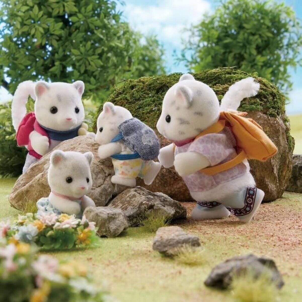 Vier kleine weiße Spielzeugtiere mit Rucksäcken erkunden eine felsige, moosige Außenlandschaft mit Blumen und Bäumen im Hintergrund.