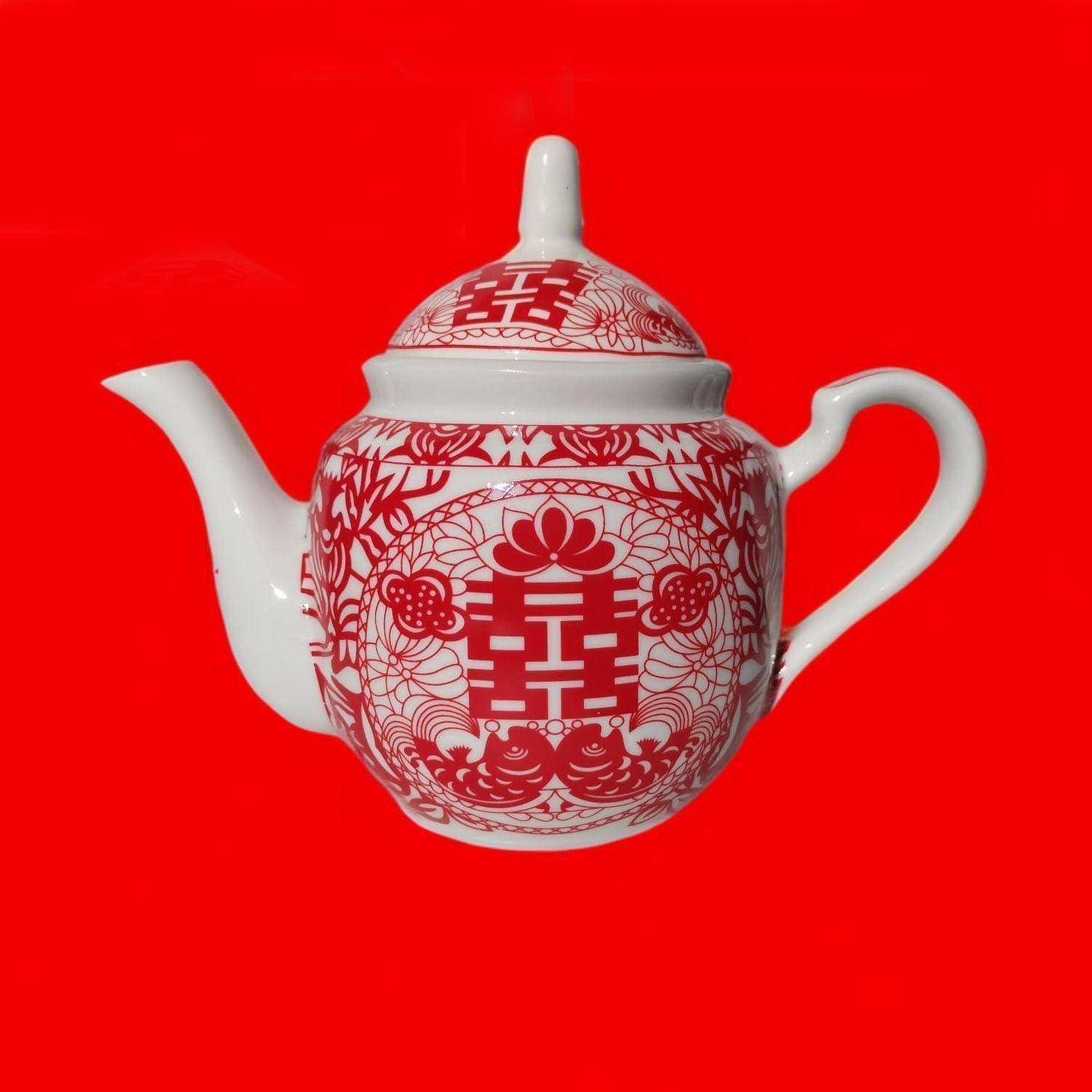 Weiße Teekanne mit roten chinesischen Dekormustern und einem Deckel, zentriert auf einem einfarbig roten Hintergrund.