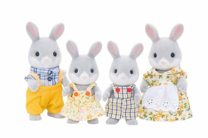 Vier Plüsch-Hasenpuppen in farbenfroher Kleidung, die nebeneinander auf weißem Hintergrund stehen.