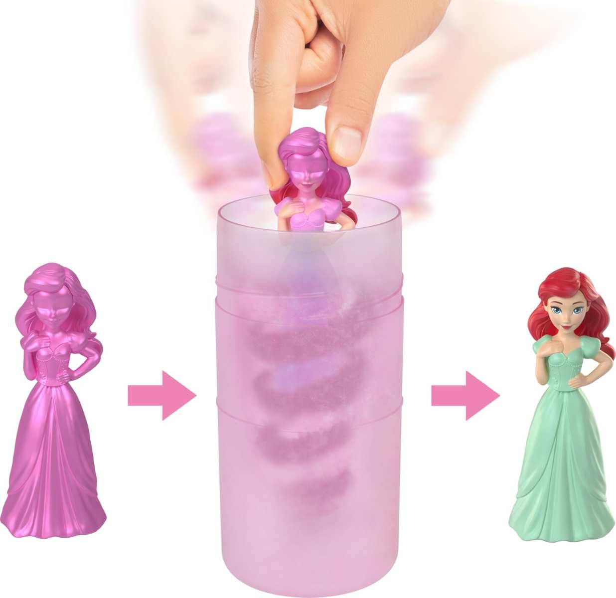 Illustration eines Farbwechsel-Spielzeugpuppenkits: Eine rosa Figur wird in einen durchscheinenden rosa Becher gesteckt und kommt als rothaarige Prinzessin in einem grünen Kleid heraus.