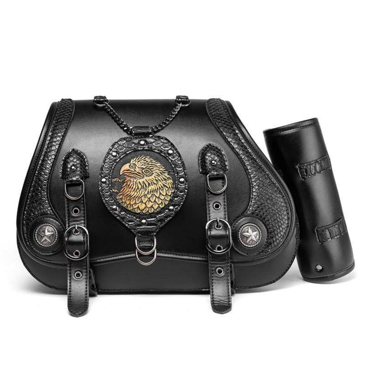 Schwarze Ledersatteltasche mit dekorativem Löwenmedaillon und Riemen, dargestellt mit einem passenden zylindrischen Accessoire auf weißem Hintergrund.