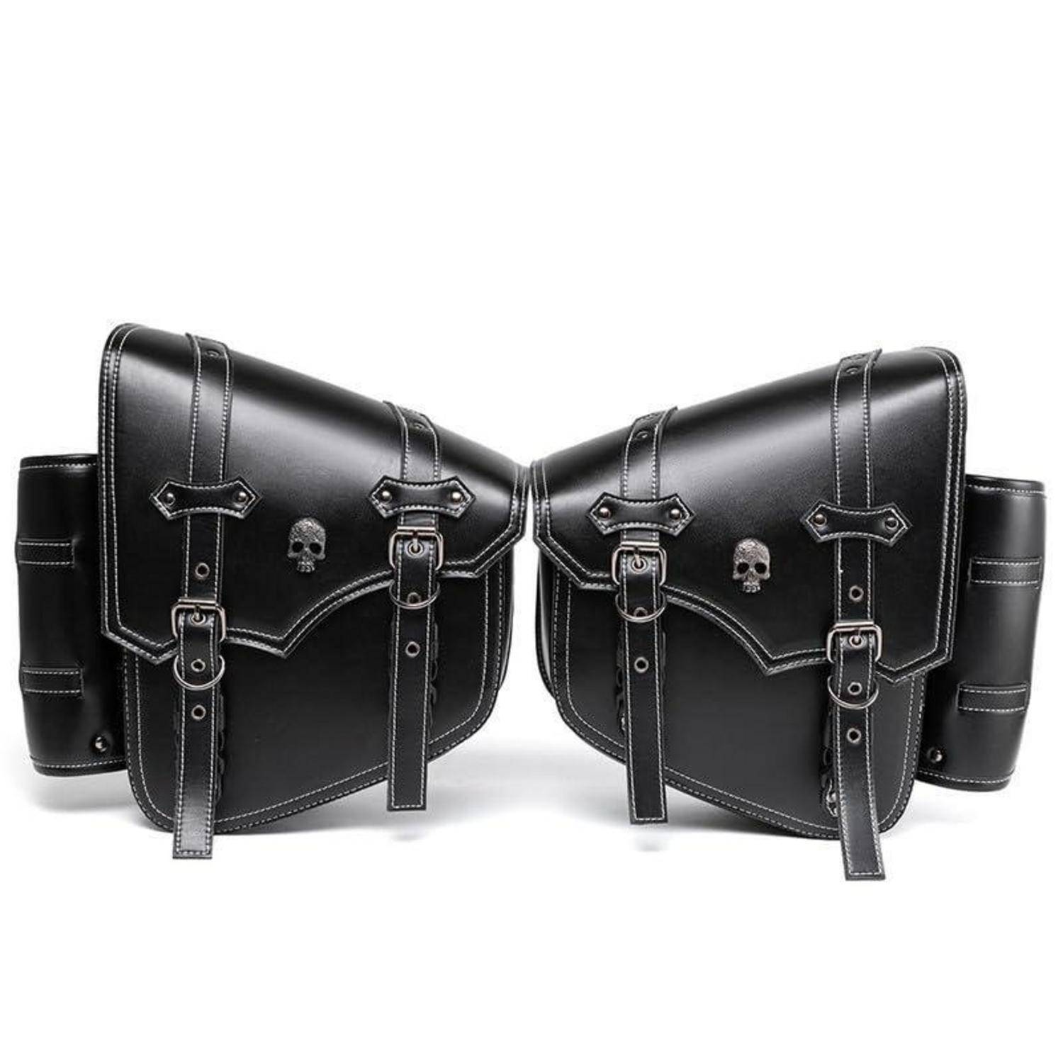 Paar schwarze Ledermotorradsatteltaschen mit Schnallriemen und Schädelemblemen auf weißem Hintergrund.