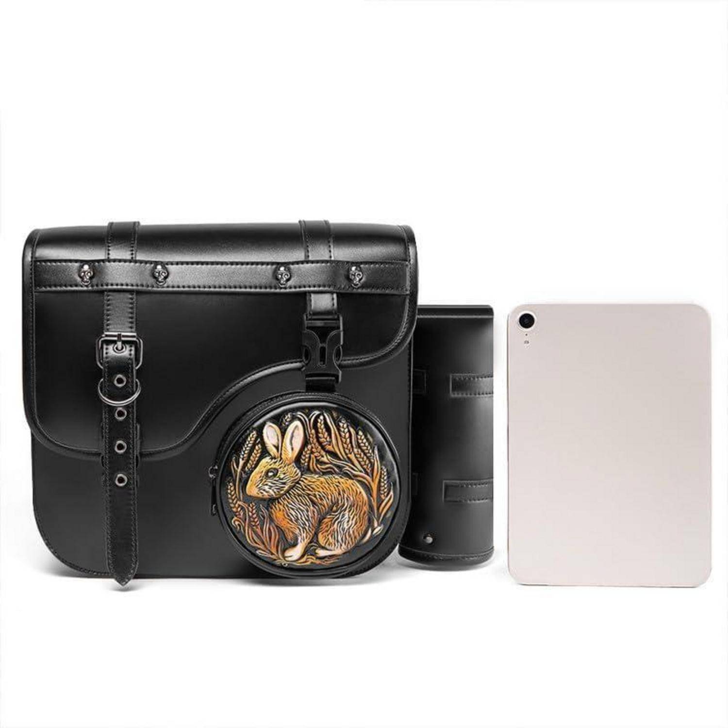 Schwarze Ledertasche und passendes rundes Portemonnaie mit Kaninchendesign, neben einem Tablet zur Größenvergleich gezeigt.