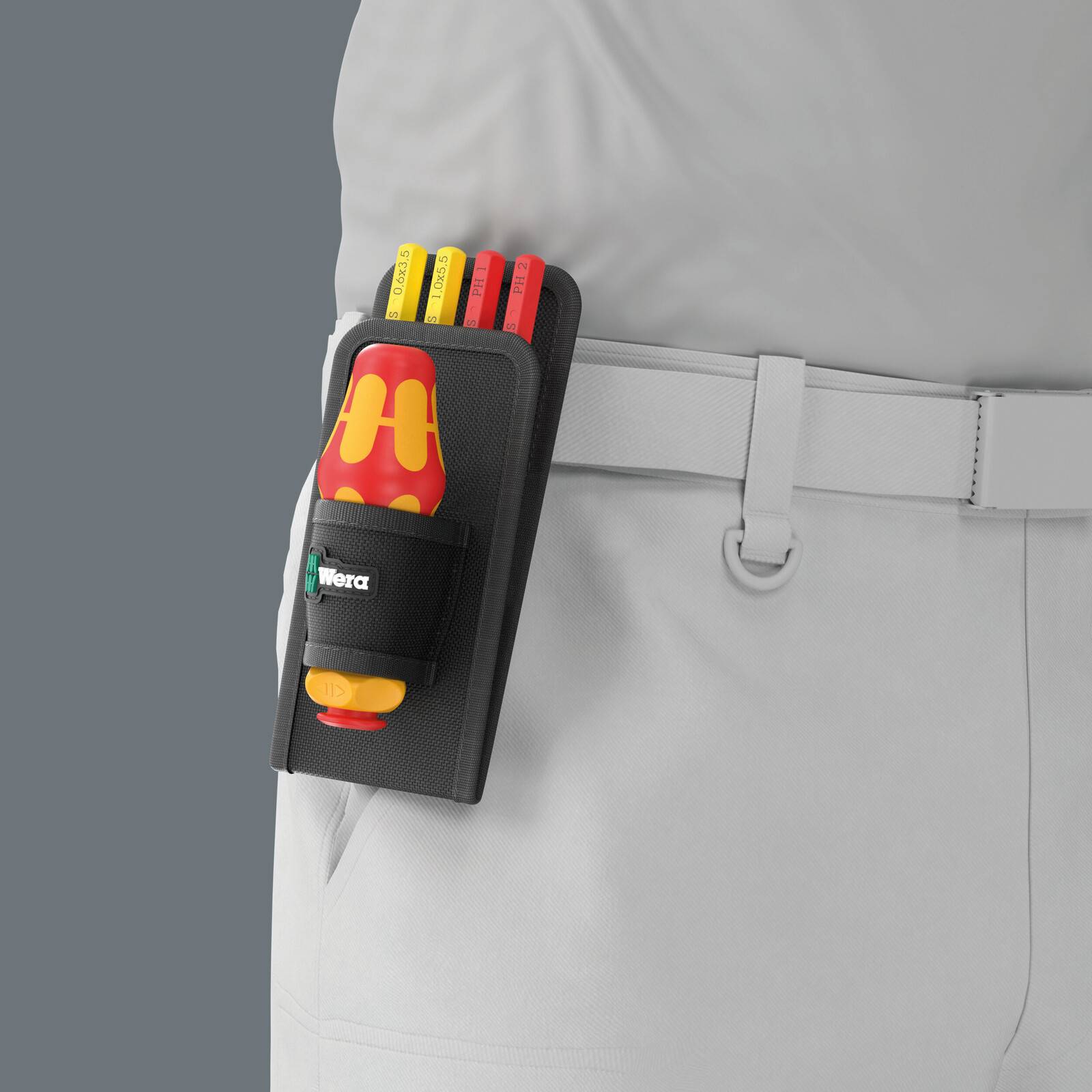 Eine an einem weißen Gürtel befestigte Werkzeugtasche auf einer grauen Arbeitsuniform, in der ein rot-gelber Schraubendreher und mehrere Markerstifte aufbewahrt werden.