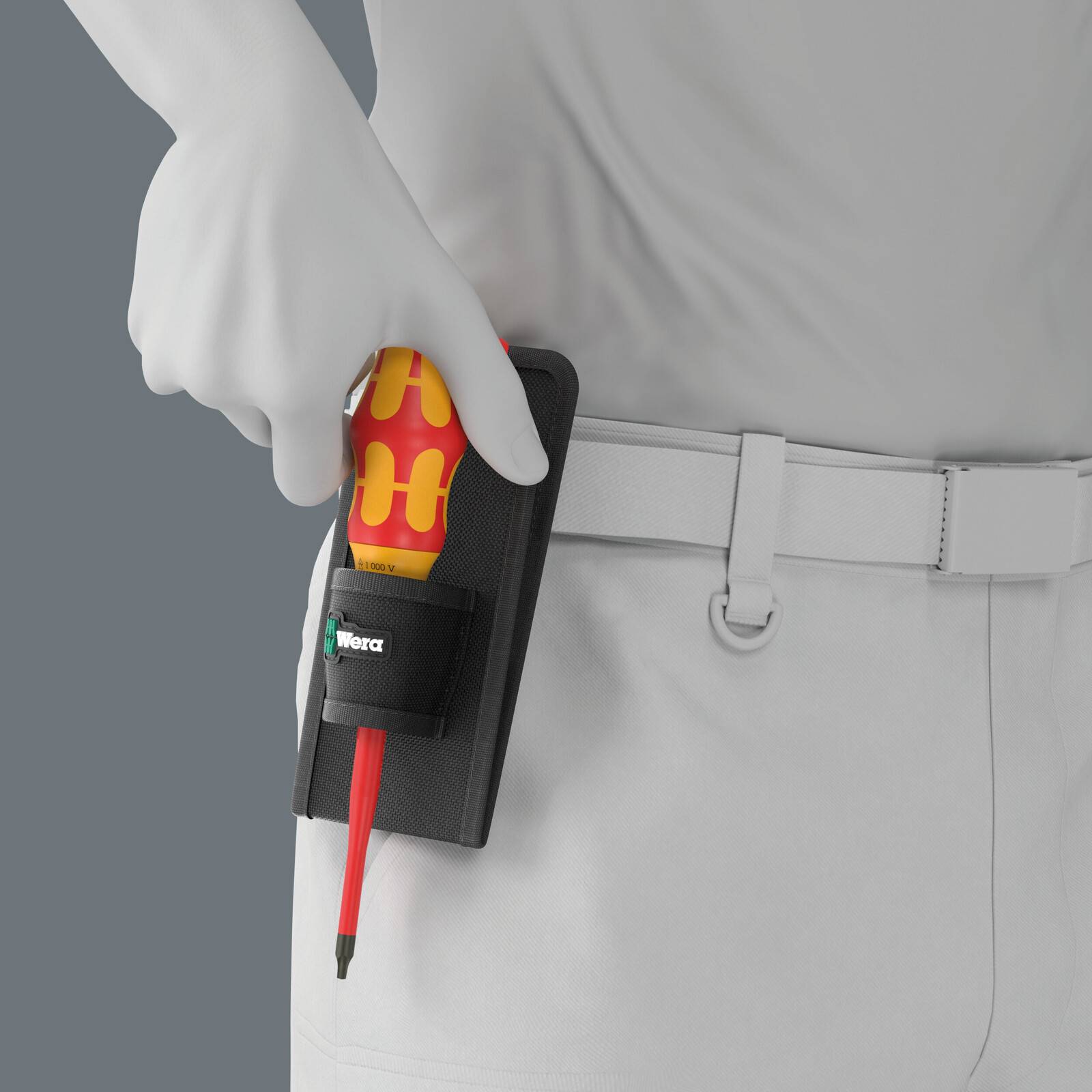 Behandschuhte Hand, die einen rot-gelben Wera-Schraubendreher in einem schwarzen Gürtelholster hält, das über weißer Arbeitskleidung mit Gürtel getragen wird.