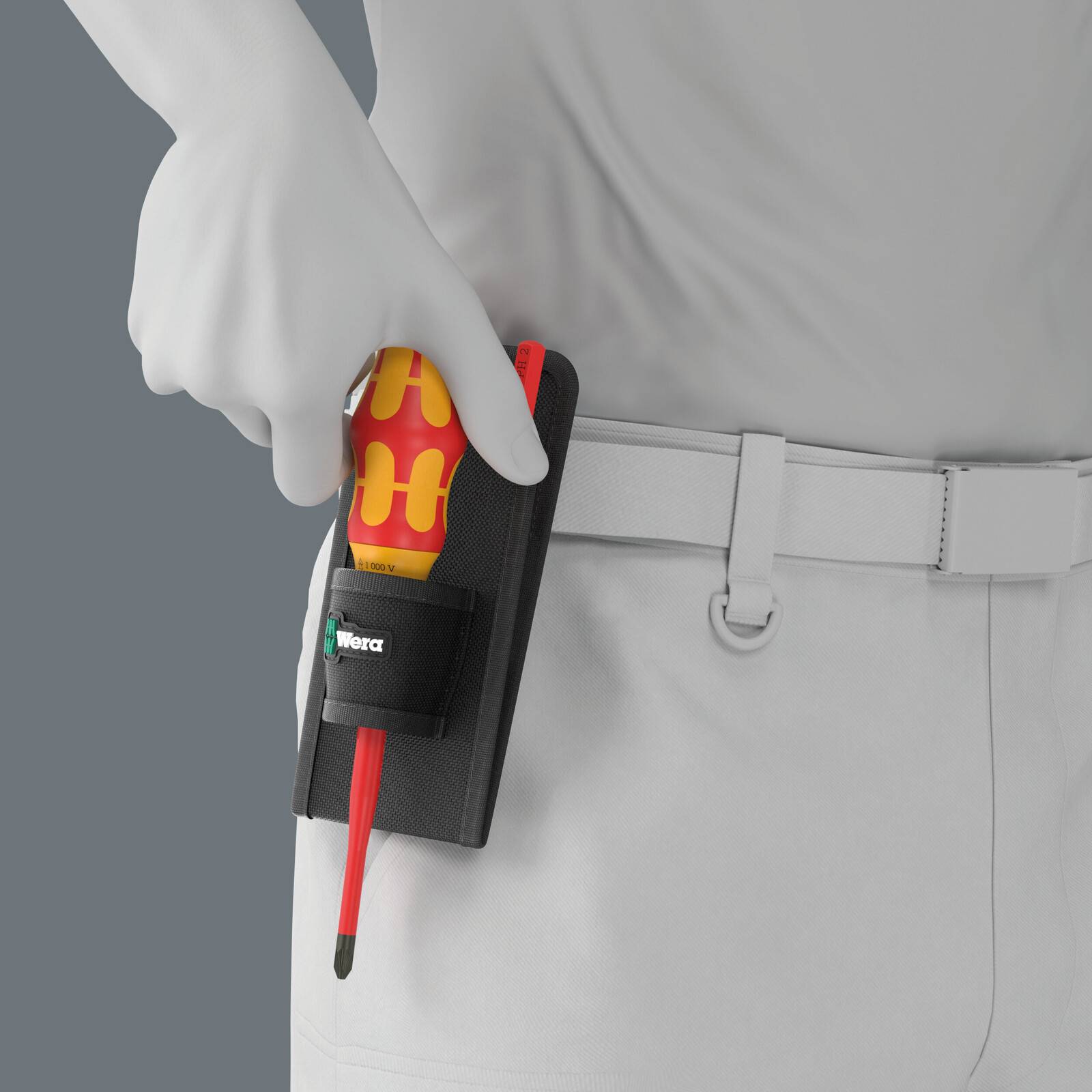 Behandschuhte Hand, die einen rot-gelben isolierten Schraubendreher in einem schwarzen Werkzeughalter an einer weißen Arbeitsuniform hält.