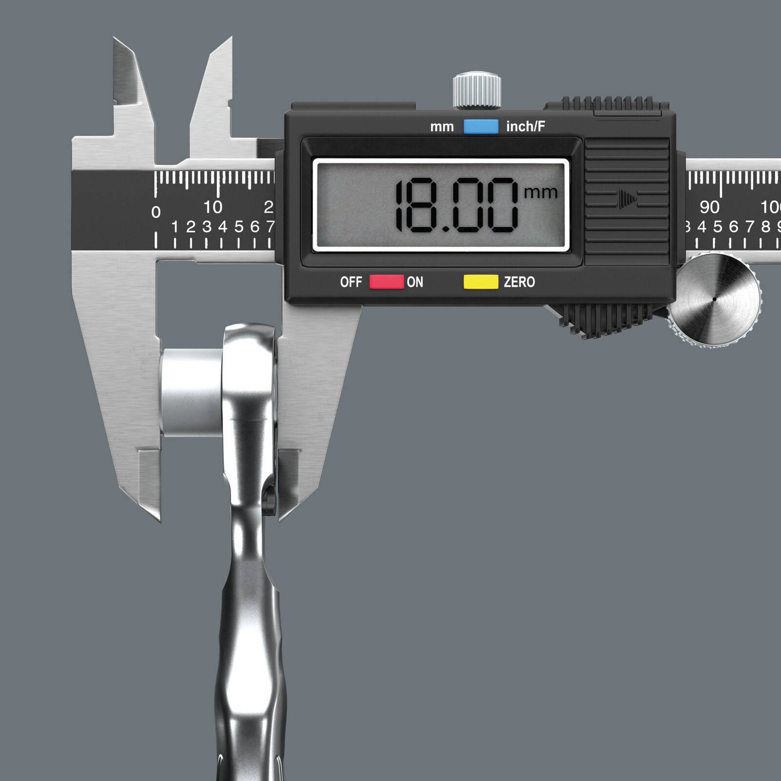 Digitale Schieblehre misst ein Metallteil, Anzeige zeigt 18,00 mm.