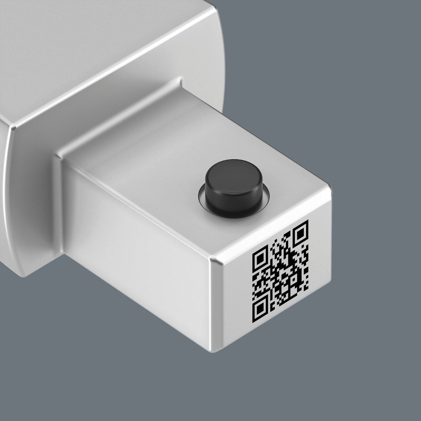 3D-Darstellung eines silbernen Stecker-Geräts mit schwarzem Knopf und QR-Code auf der Stirnseite, dargestellt vor grauem Hintergrund.