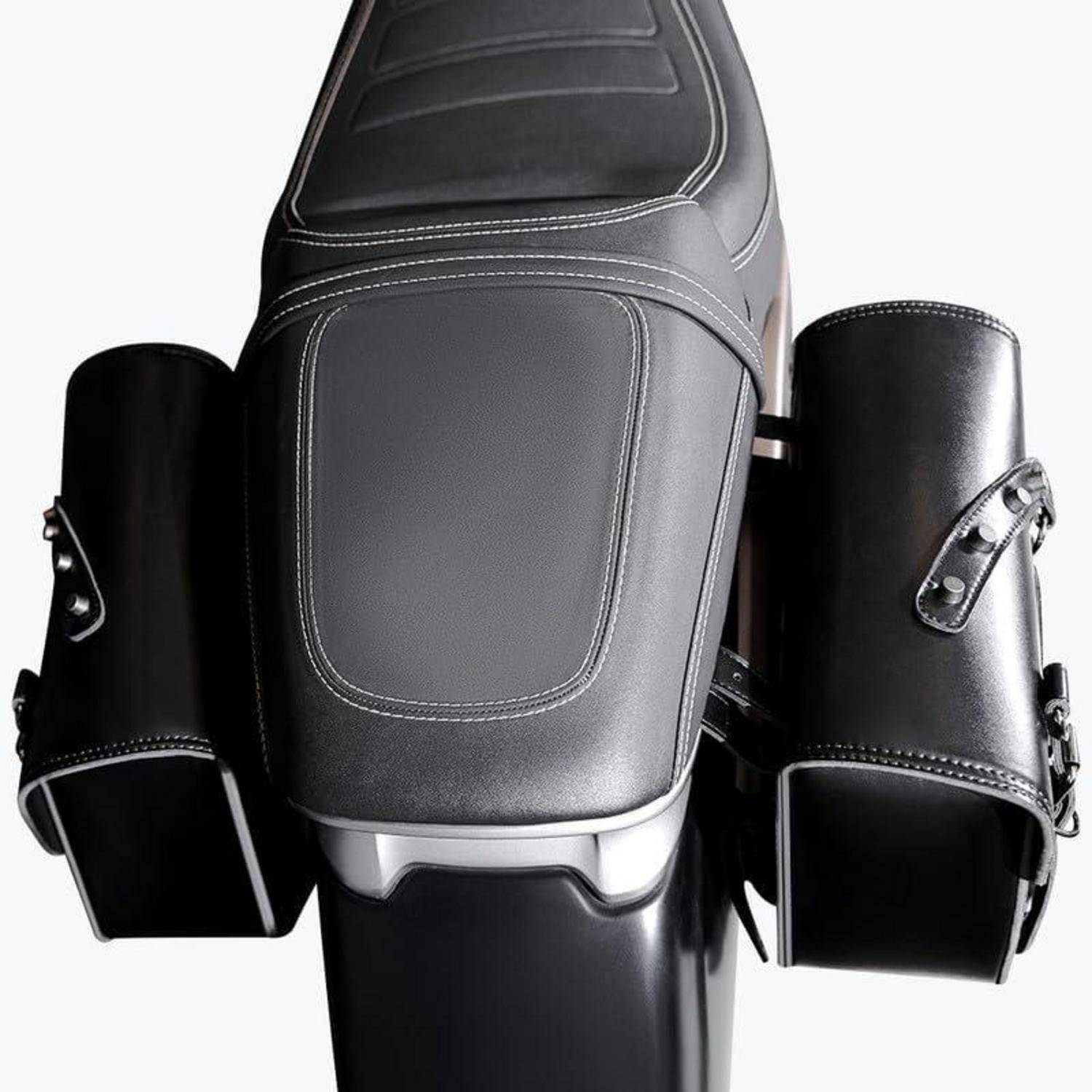Schwarzer Motorradsitz mit zwei seitlich angebrachten Ledersatteltaschen auf weißem Hintergrund.