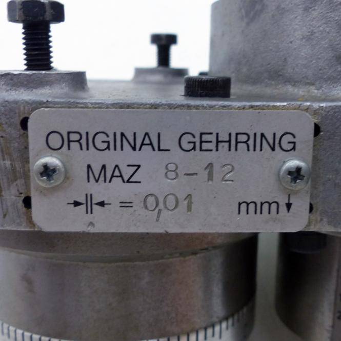 Nahaufnahme eines Metallmaschineteils mit einer Einstellplatte mit der Aufschrift 'ORIGINAL GEHRING MAZ 8-12' und '0,01 mm'.