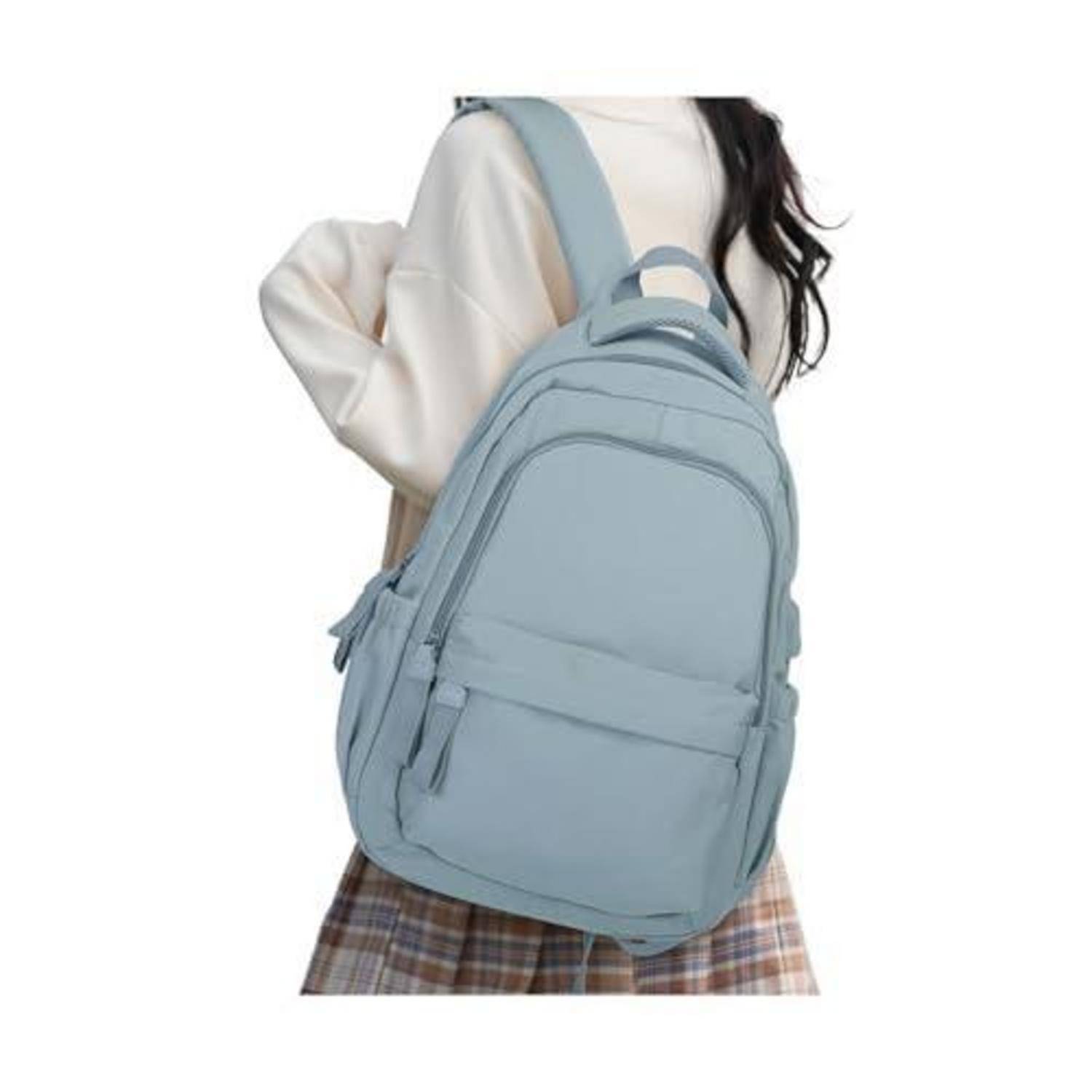 Person, der einen hellblauen Rucksack mit vorderen Reißverschlusstaschen trägt, von hinten vor weißem Hintergrund gezeigt.