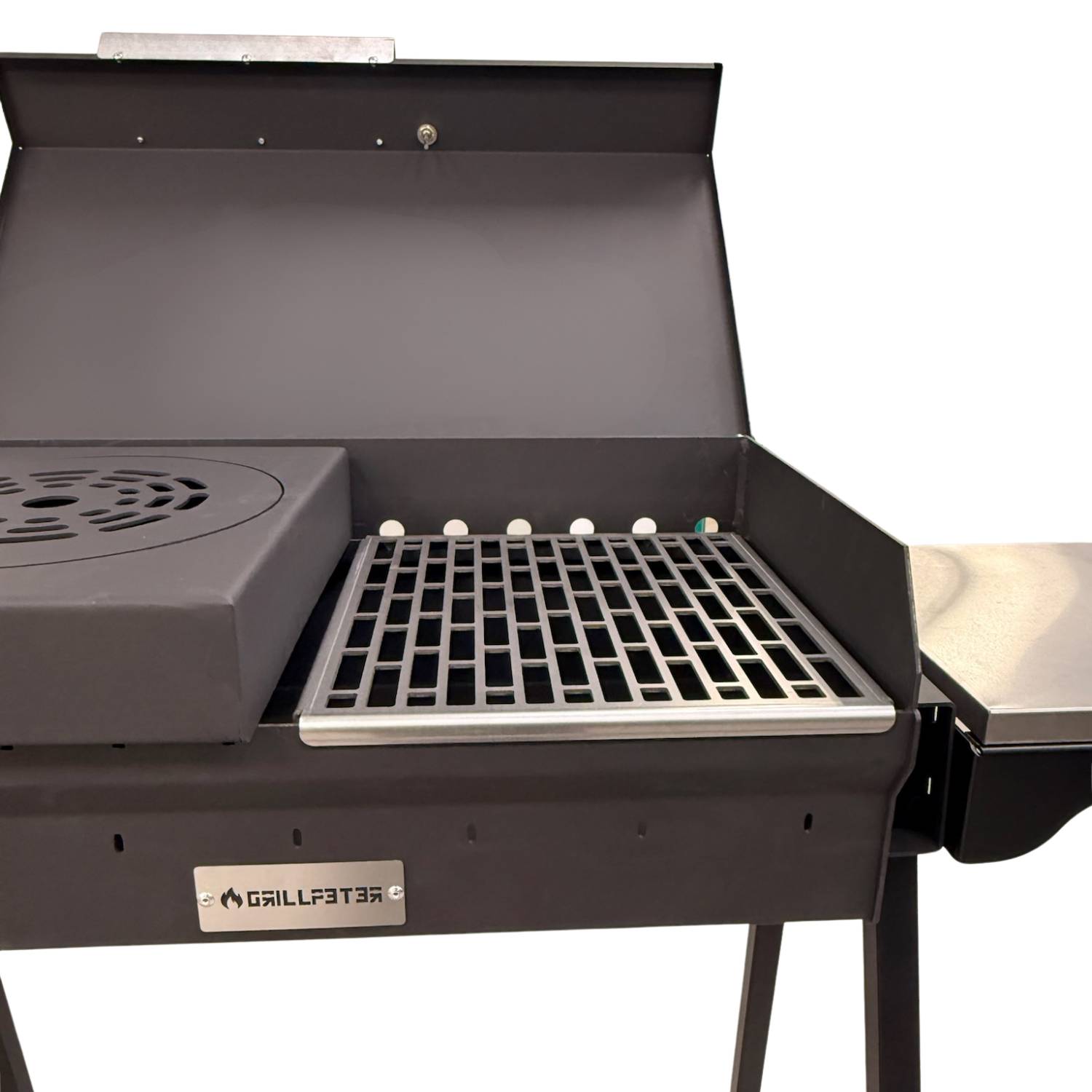 Offener schwarzer Außengrill mit angehobenem Deckel, seitlichem Ablageregal und Markenschild 