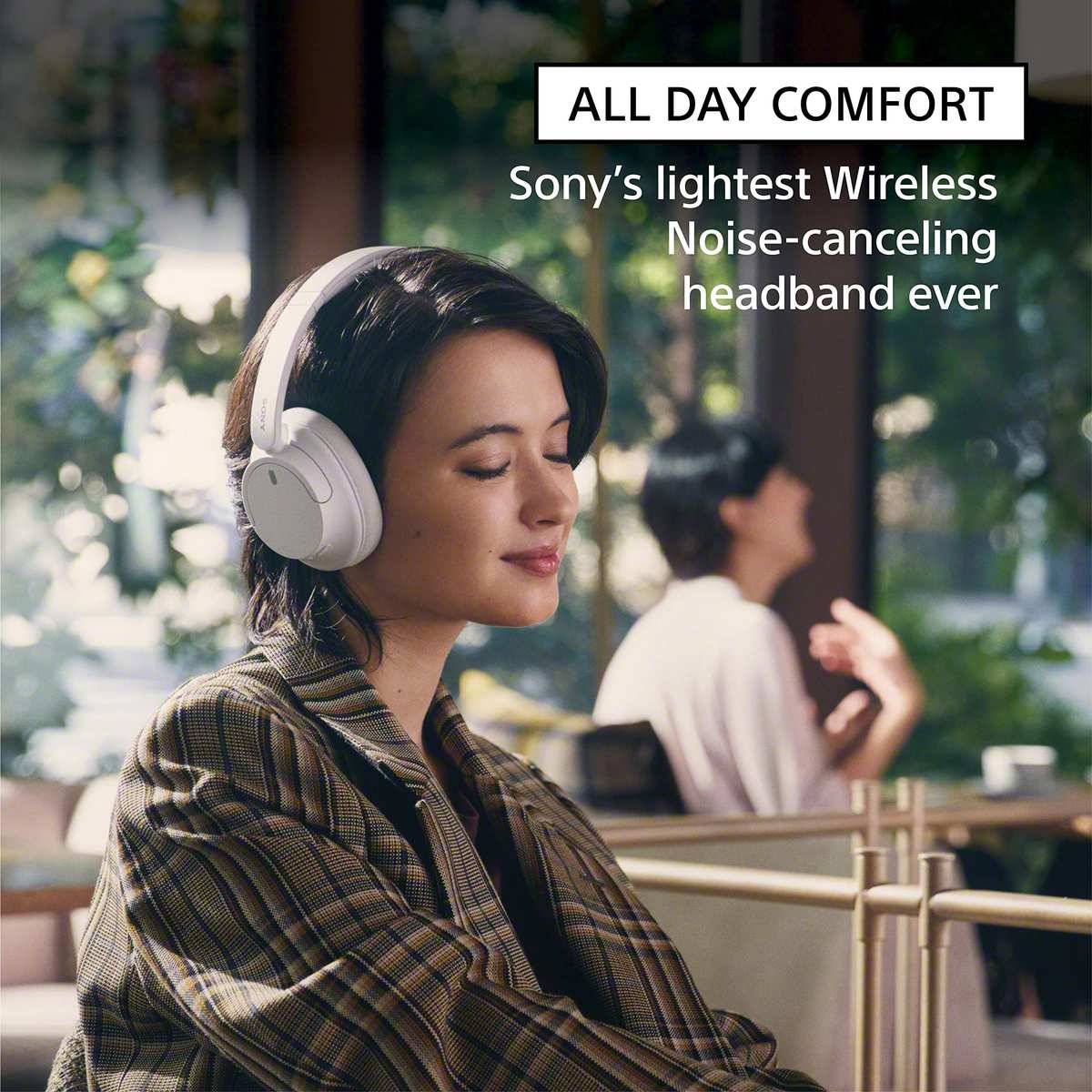 Frau, die weiße Sony-Kopfhörer mit Noise-Cancelling und Over-Ear-Design trägt, die Augen in einem Café geschlossen, mit Anzeigentext: „GANZTÄGIGER KOMFORT